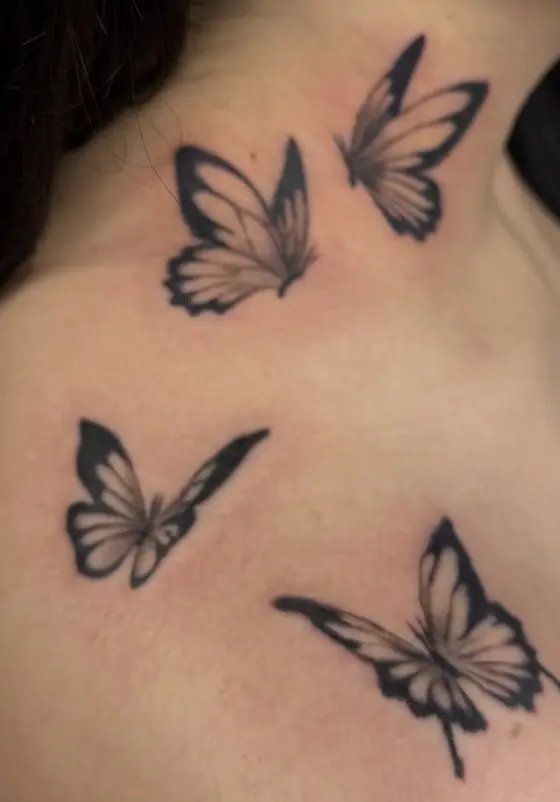 Black butterflies tattooed across a neck and shoulder.